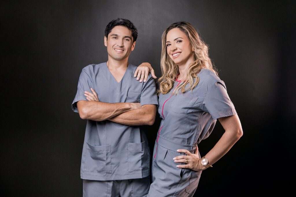 smiling young male and female locum tenens physician against a black background